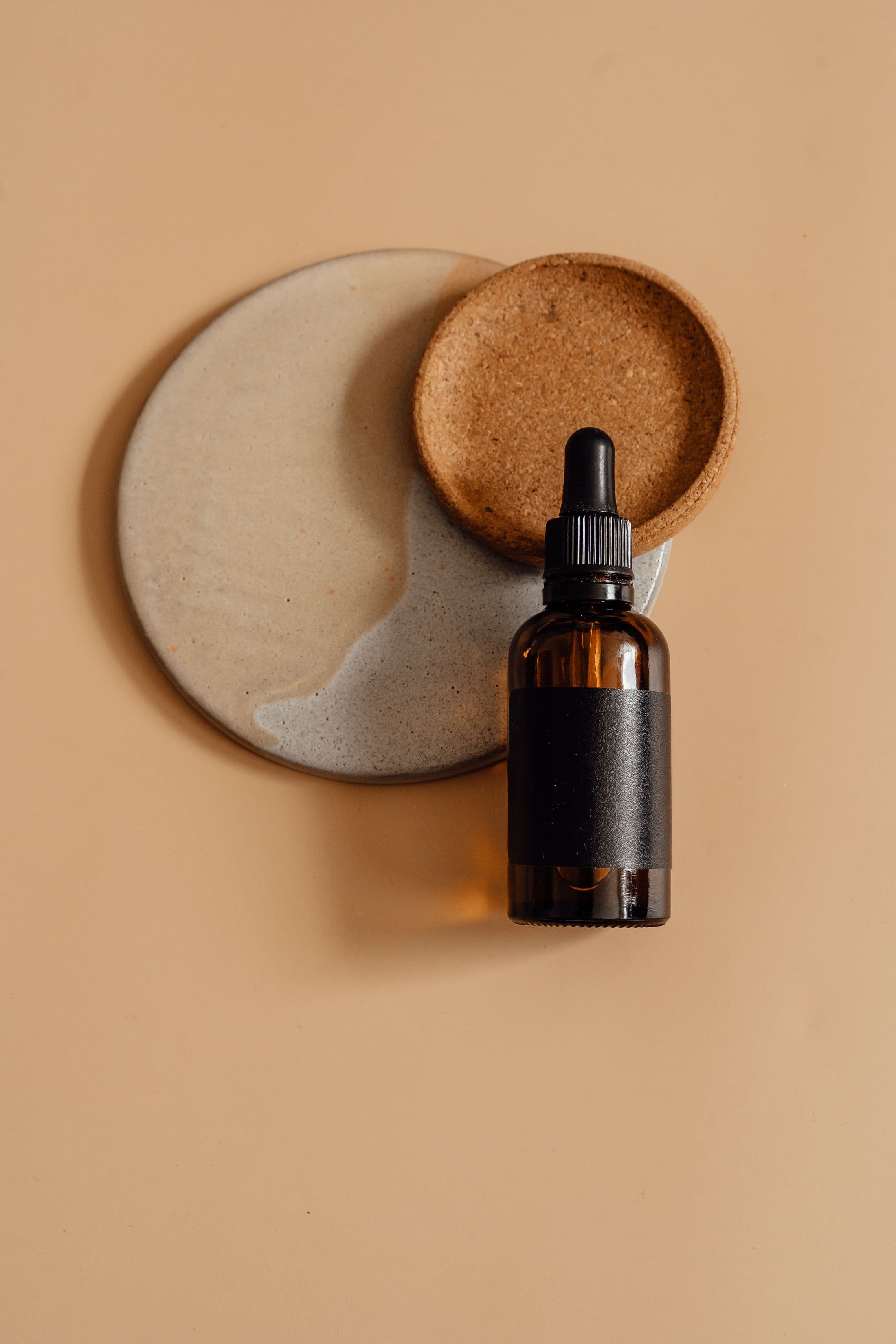 Flacon d’huile d’argan en verre ambré sur pierre